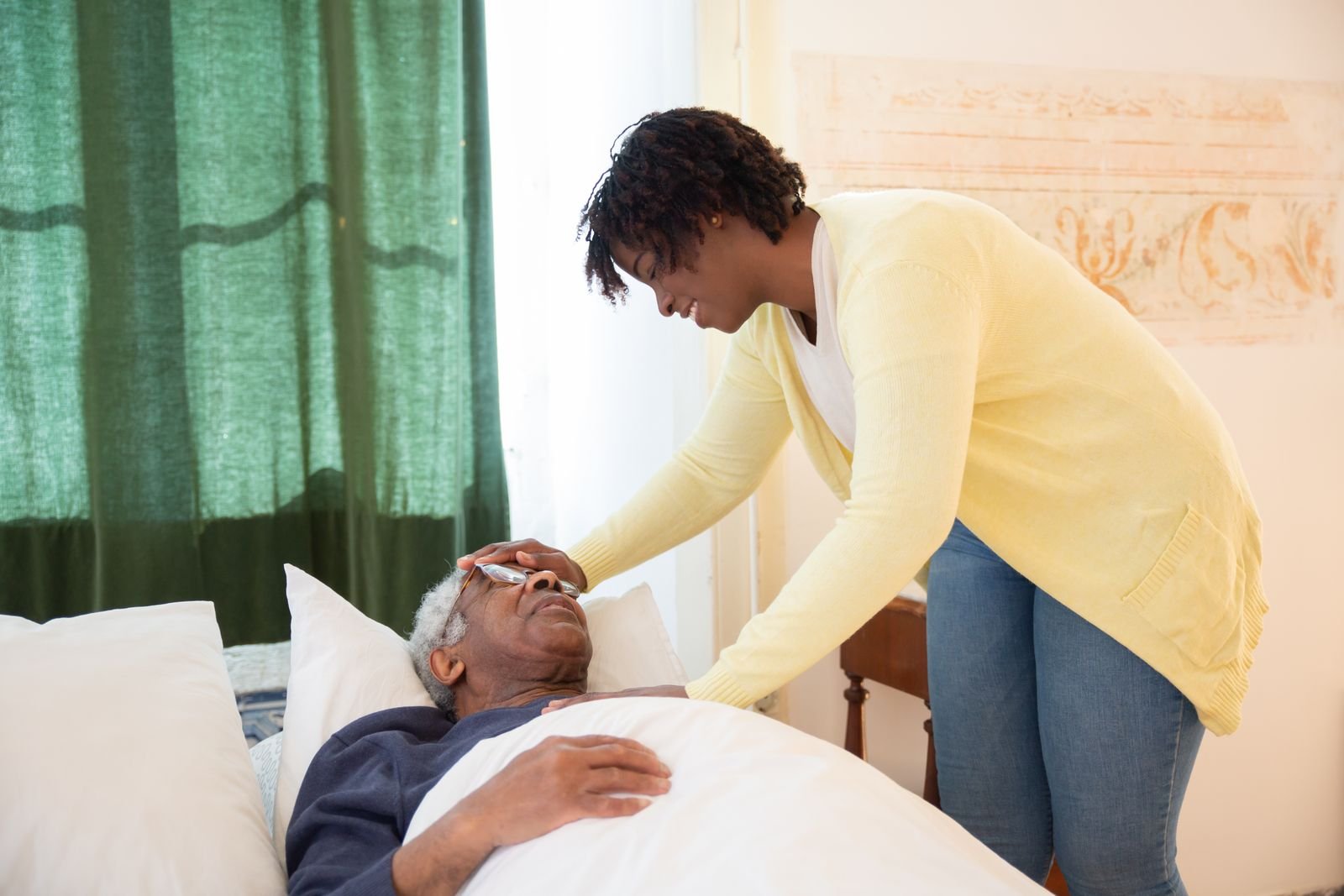 A daughter gently comforting her elderly father at home